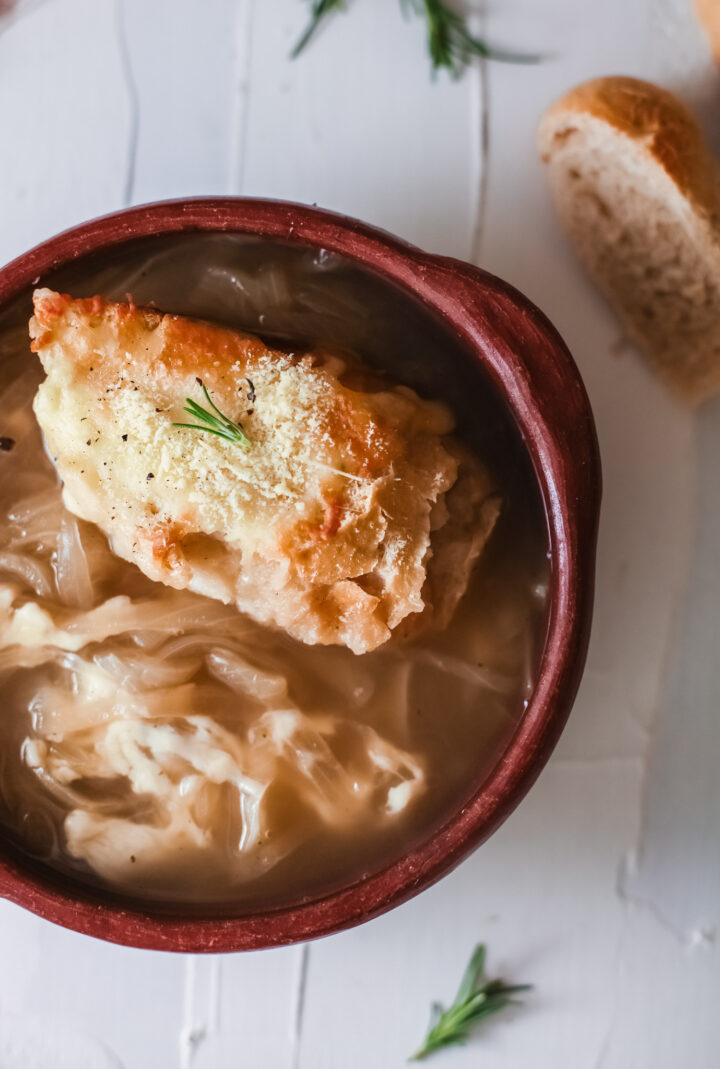 Onion soup in a bowl with crusty bread.