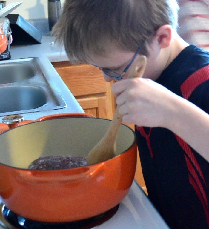 adorable boy making lasagna soup