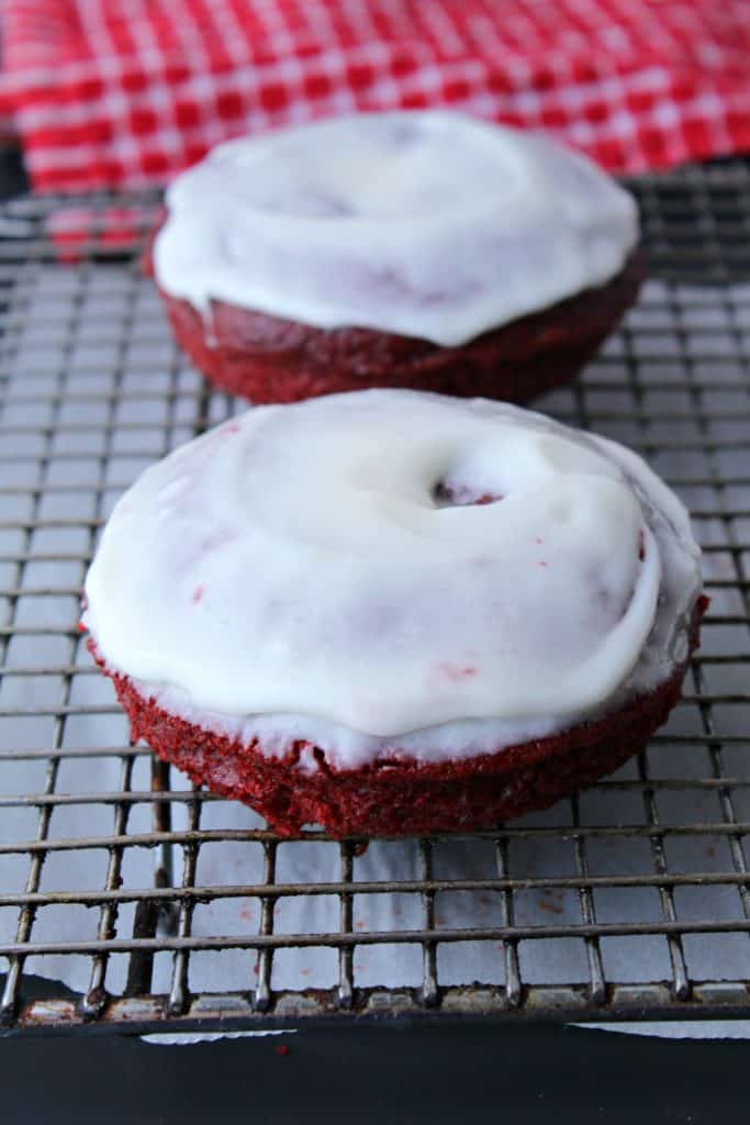 Red Velvet donuts with cream cheese icing on a cooling rack