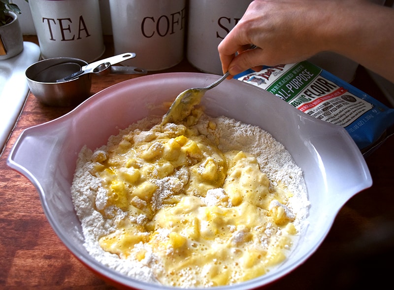 Pineapple cake batter being mixed in a mixing bowl.