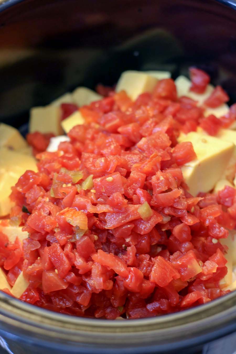 Ingredients for Queso Dip in the slow cooker. Ro-tel, Velvetta, Cream Cheese