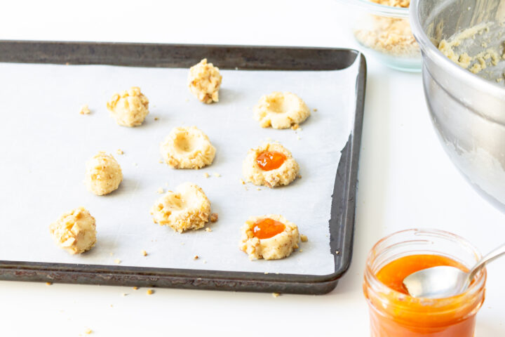 filling thumbprint cookies with jam