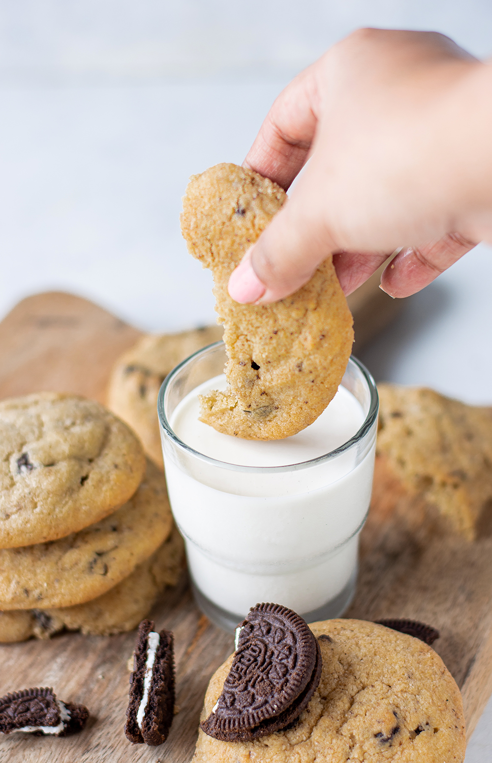 Dipping a cookies and cream cookie into a glass of milk for a delicious snack!