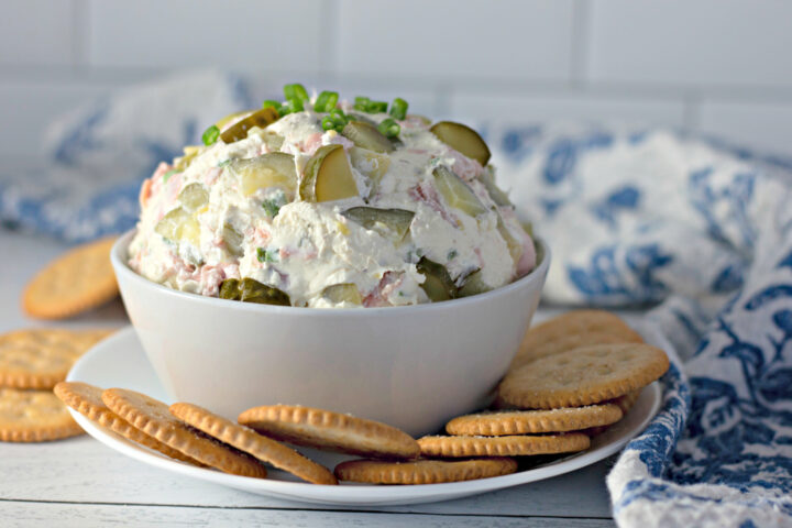 dill pickle dip with ham in a bowl with crackers